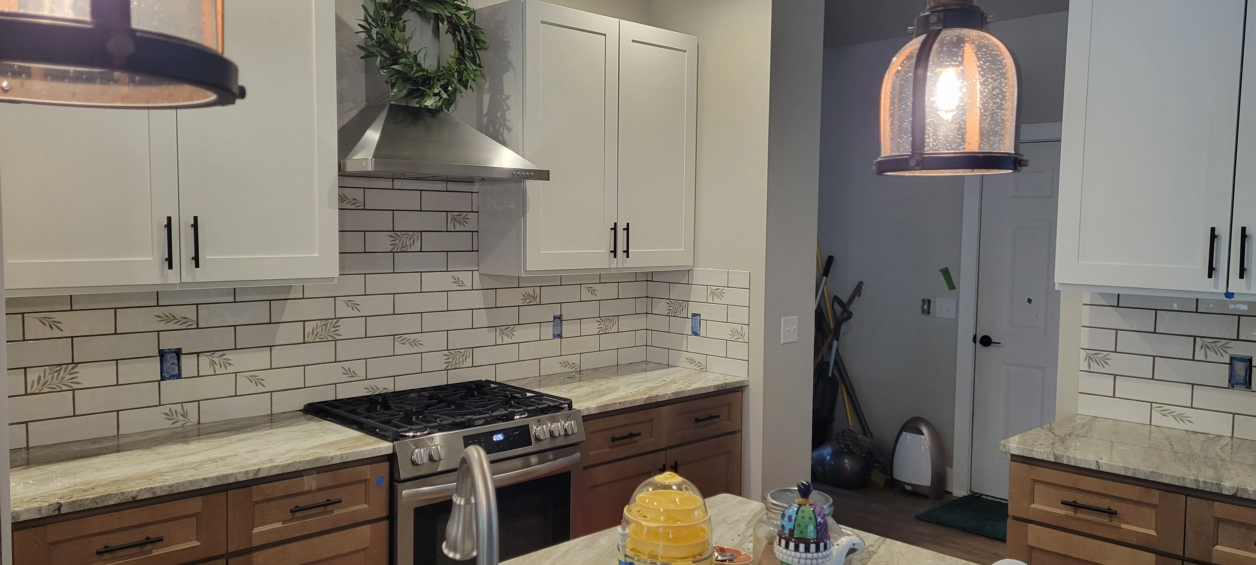 Kitchen with white and wood cabinetry, decorative subway tile backsplash, granite counters, and stainless steel appliances