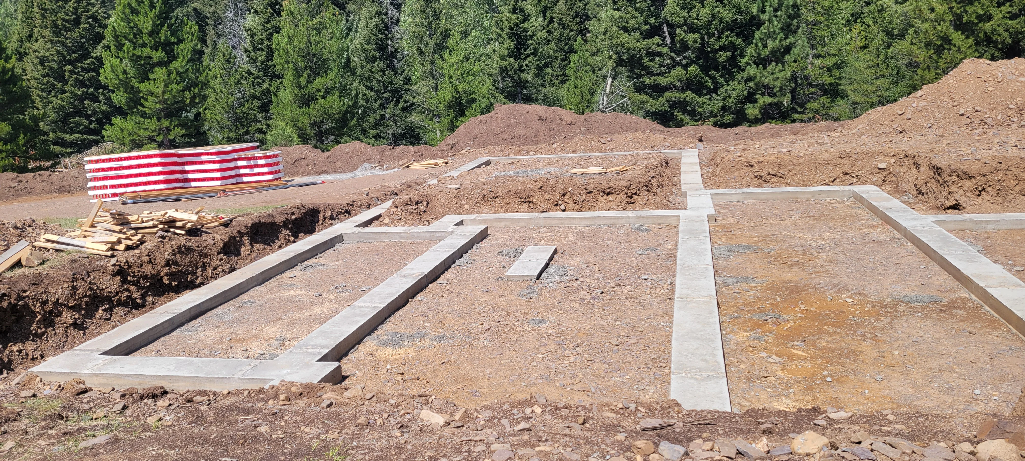 Concrete foundation with beam pockets and perimeter footings on prepared dirt site