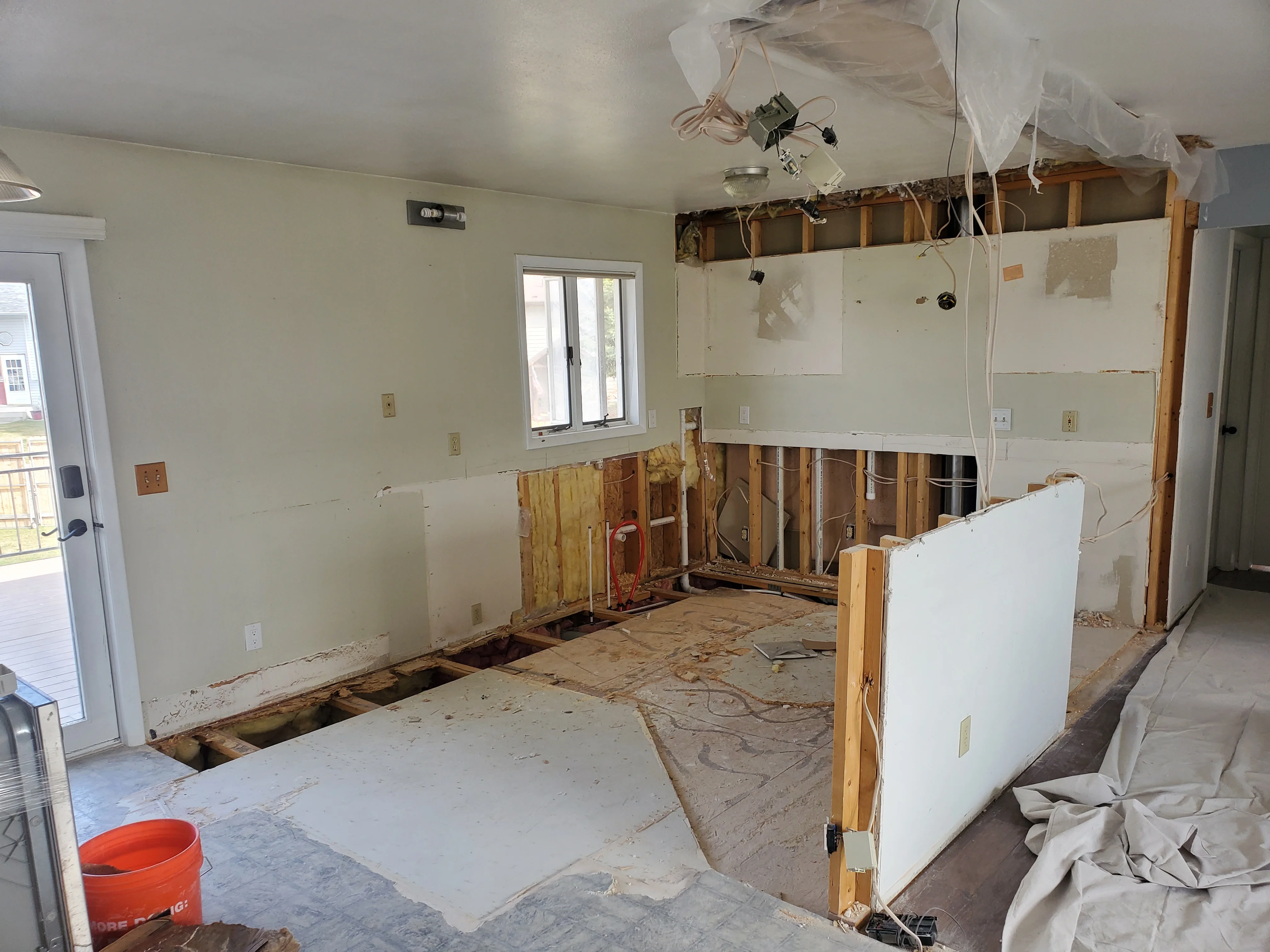 Kitchen renovation with drywall, wooden framing, and electrical rough-in work in progress