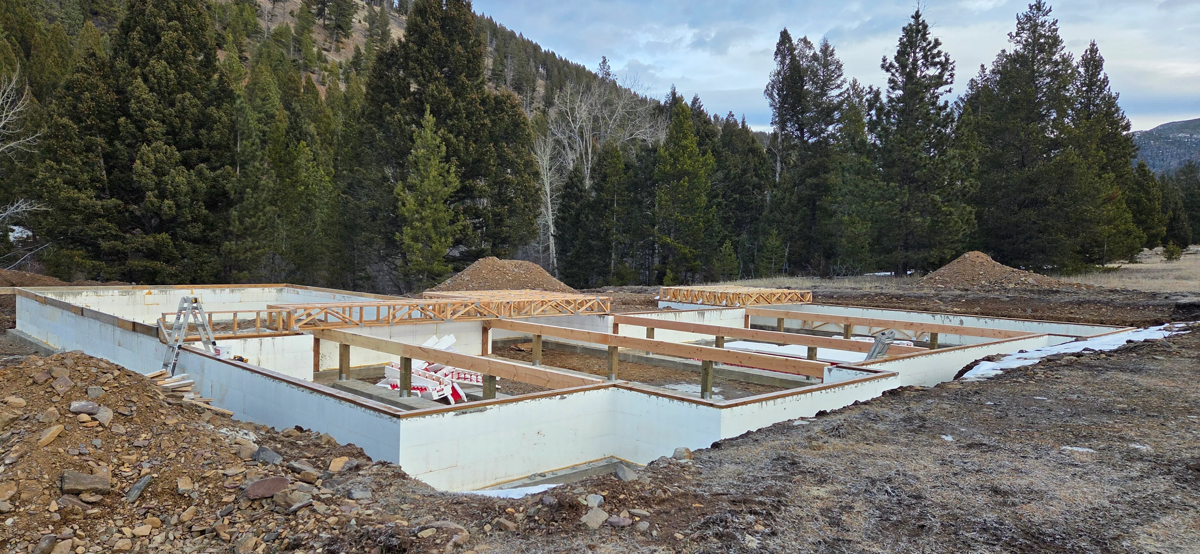 Concrete foundation with wood framing and roof trusses during residential construction