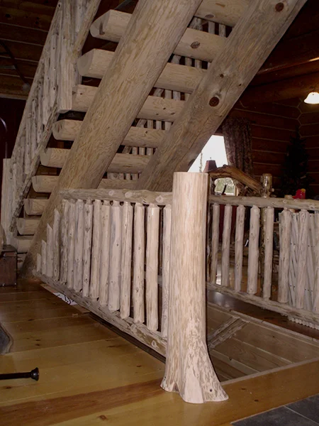 Timber frame loft with exposed beams, mortise details, and custom wood railings with turned balusters